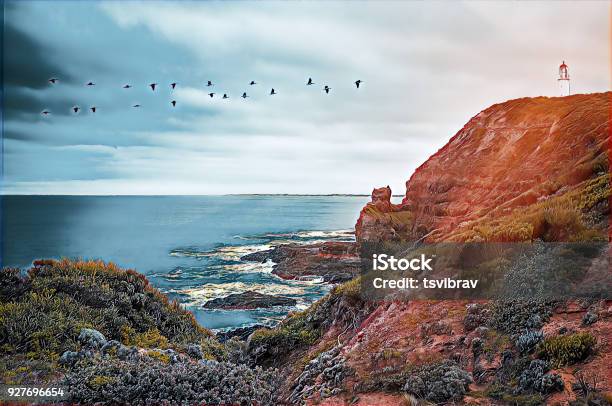 Illustration Of Birds Flying Towards Lighthouse Shining Light Over Ocean Stock Photo - Download Image Now