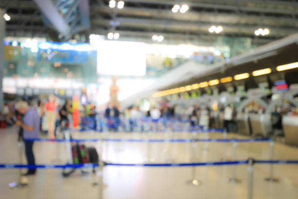 istock Blurred image of airport check-in counters with passengers and crowd of people control barriers with bokeh in international airport, que, travel, tourism, business concept Abstract Blur Background. 927699456