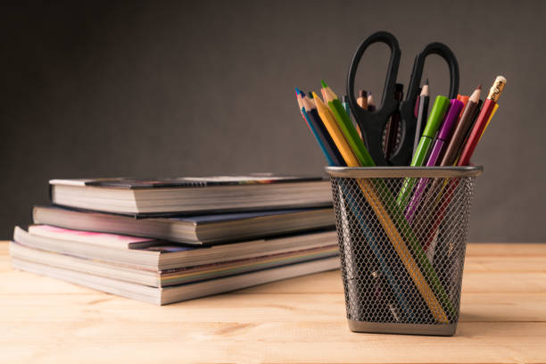 color pencil in pen pot and book on working desk