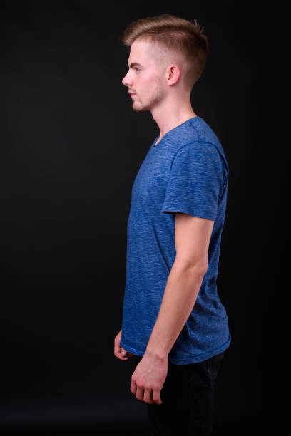 istock Young handsome bearded man with blond hair against black background 927721532