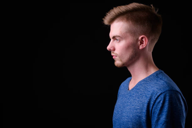 istock Young handsome bearded man with blond hair against black background 927721646
