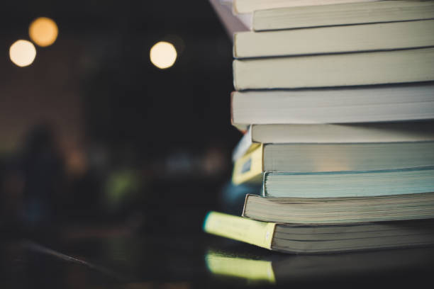 istock piles of books on table over blurred library background. 927727540