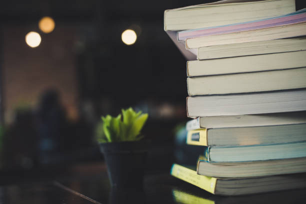 istock piles of books on table over blurred library background. 927727646