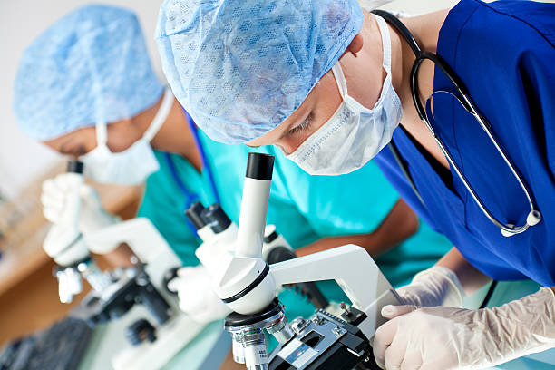 istock Female medical researchers looking at samples on microscopes 92773113