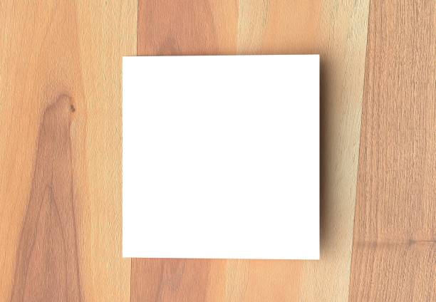 istock Bifold square brochure mock up on wooden background. 3D illustrating. 927731250