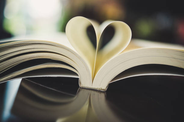 istock Curled paper heart shape with blurred bokeh of cafe. 927733312