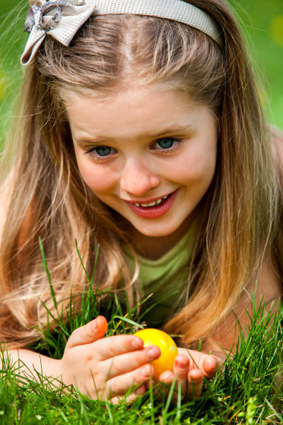 istock Child with bow on head find easter egg outdoor. 927733524