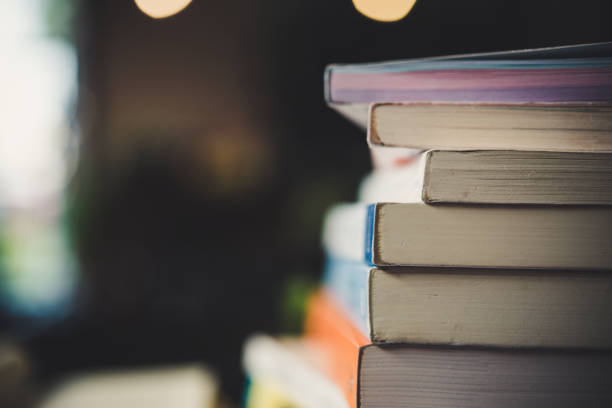istock piles of books on table over blurred library background. 927736914