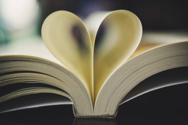istock Curled paper heart shape with blurred bokeh of cafe. 927737068