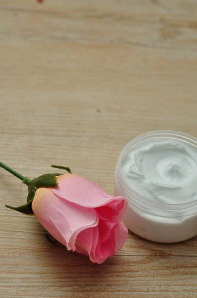 istock A pink artificial rose with a jar of white body lotion 927737306