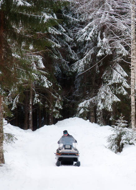 istock A man is riding a snowmobile in the winter forest 927737978