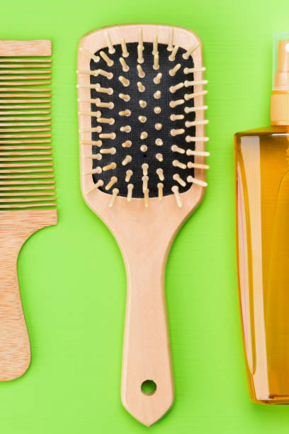 istock comb for combing hair and spray on a green background 927738082