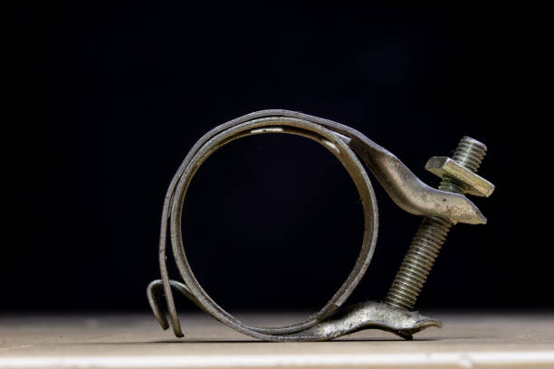 Old garden accessories. Rusty hose clamps on the workshop table. Light background.