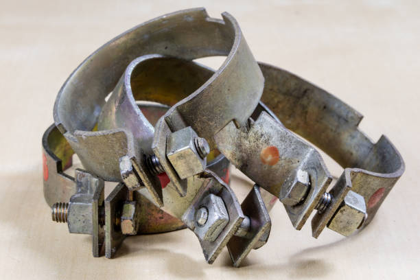 Old garden accessories. Rusty hose clamps on the workshop table. Light background.