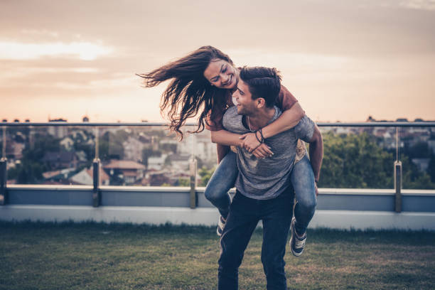 istock Carefree couple having fun while piggybacking on a penthouse balcony. 927744158