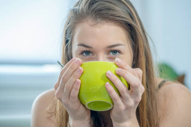 istock pretty young woman drinking a tea bowl 927744186