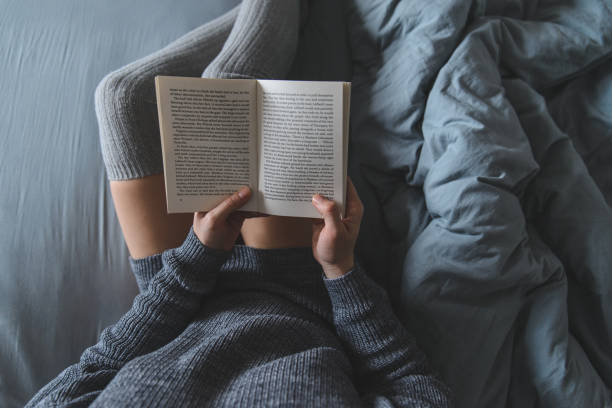 istock woman read book in bed with grey sheets 927745022