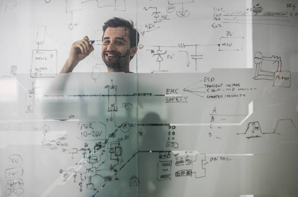 istock Happy male engineer making a business plan by drawing a diagram on a glass wall. 927750902