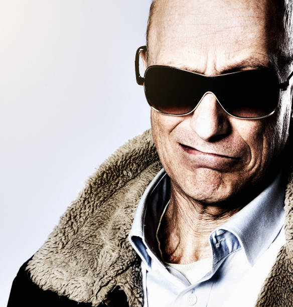 istock Mature man in sunglasses and sheepskin jacket grimaces 927752054