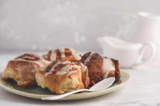 istock Homemade cinnamon buns in glaze on a light plate, light background, copy space. Breakfast concept. 927753664