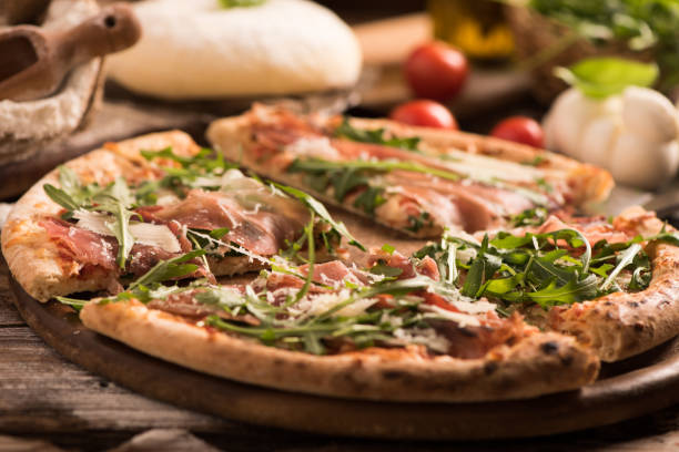 istock Italian Pizza with rocket salad on wooden table 927756774