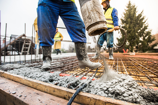 Trabajadores de la construcción verter cemento en techo photo