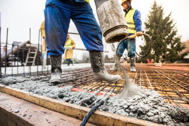 Construction workers pouring cement on roof Manual workers pouring cement through pipe on roof. concrete stock pictures, royalty-free photos & images