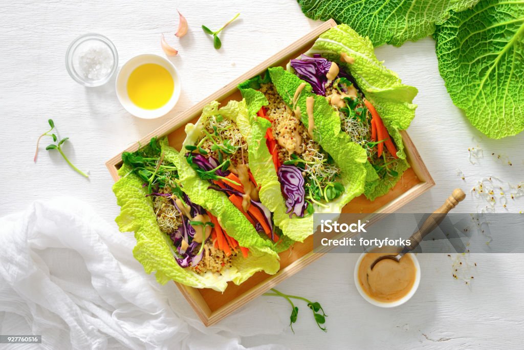 Vegan detox spring rolls with quinoa, sprouts and Thai peanut sauce Vegan detox spring rolls with quinoa, sprouts and Thai peanut sauce, view from above, flat lay Vegan Food Stock Photo