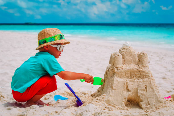 istock little boy building sand castle on beach 927764072