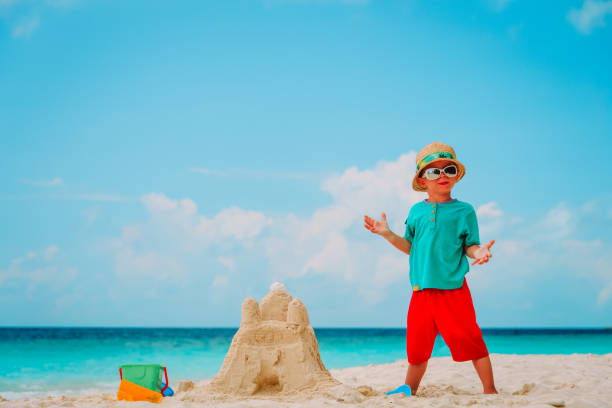 istock little boy building sand castle on beach 927764098