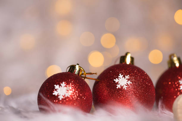 istock Red blazing Christmas balls on white artificial fur. Extreme closeup. 927768668