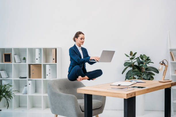 mulher de negócios usando laptop enquanto levitando no local de trabalho - pairando - fotografias e filmes do acervo