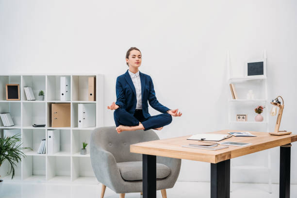 istock young businesswoman meditating with closed eyes while levitating at workplace 927775492