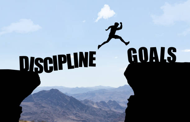istock Man jumping over abyss with text DISCIPLINE/GOALS. 927775638