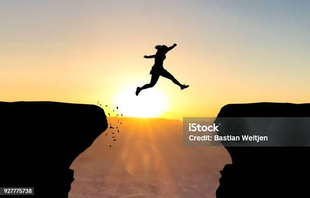 Woman Jumping Over Abyss Stock Photo - Download Image Now - Courage, Jumping, Women