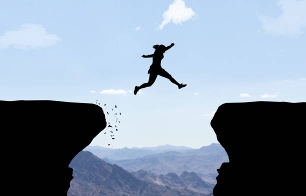istock Woman jumping over abyss. 927775760
