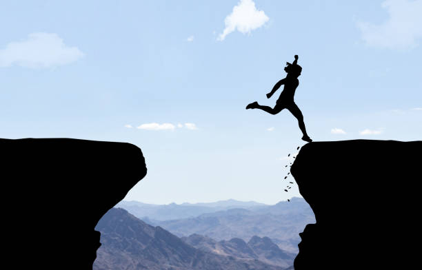 istock Woman landing after jumping over abyss. 927775766