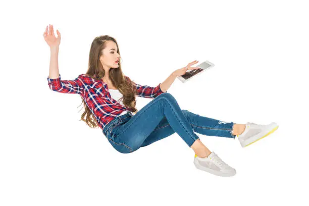 young woman using digital tablet while levitating isolated on white