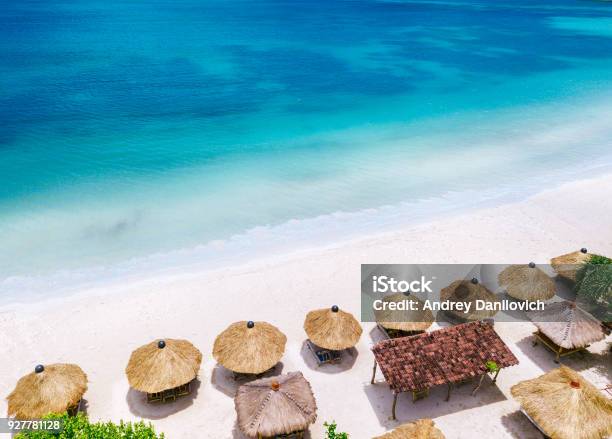 Straw Beach Umbrellas And Blue Ocean Beach Scene From Above Stock Photo - Download Image Now