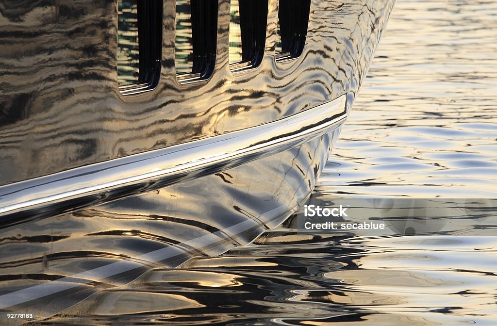 Super yacht hull reflections Large super yacht hull reflecting the water with ripples and the soft light of the sunset. Luxury Yacht Stock Photo