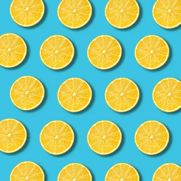 Photo of Lemon slices pattern on vibrant turquoise color background