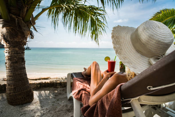 istock Woman relaxing on a deck chair during summer day on the beach. 927794934