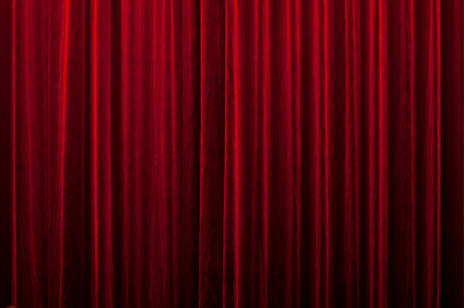 close-up of a closed red velvet curtain in theater