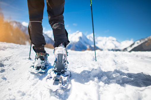Walk with snowshoes in the snow during mountain holidays.