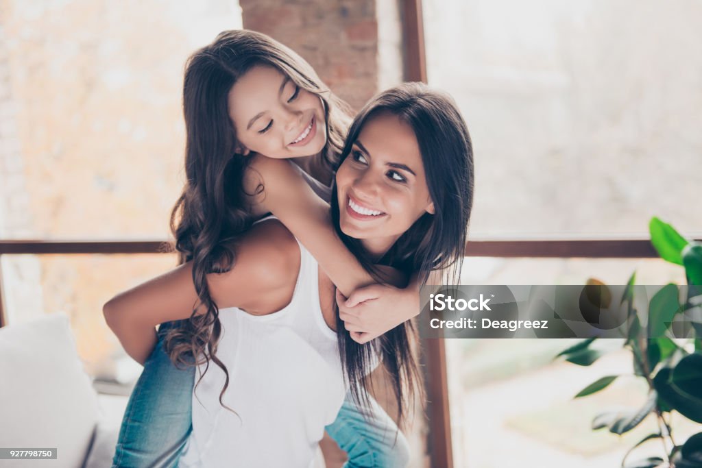 Wir sind die meisten coole Zeit zusammen herum, zum Narren! Glückliche schöne Mutter hält Tochter auf dem Rücken - Lizenzfrei Mutter Stock-Foto