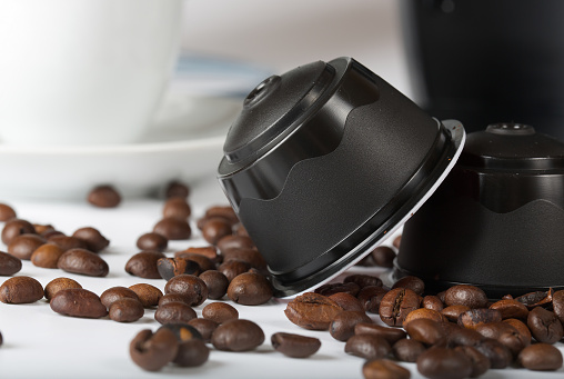 Coffee capsules and coffee beans. Closeup