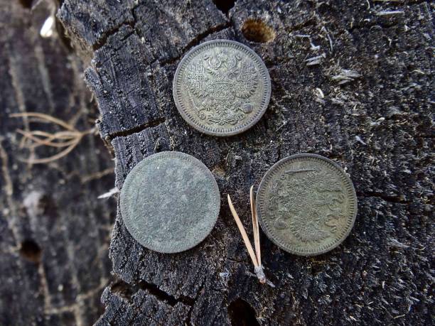 istock three silver coins on gray wood in the open air 927806982