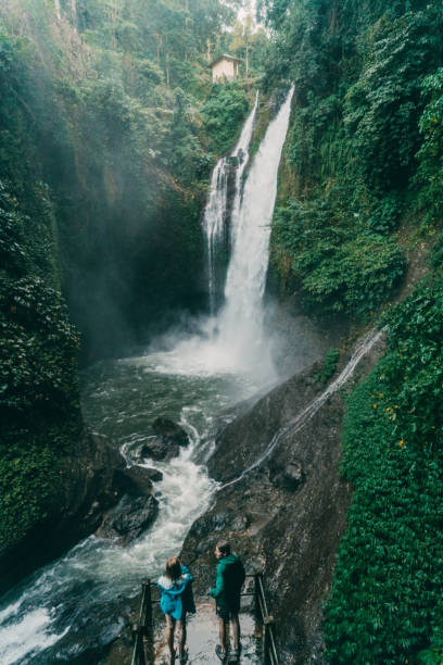 istock Couple looking at   waterfall in tropical rainforest 927809418