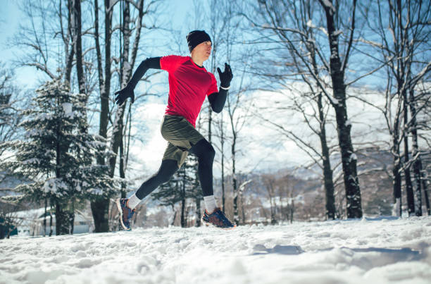 istock Young man running at winter in park 927813330