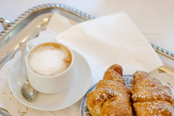 istock Cappuccino and croissant on a tray - italian breakfast 927813916
